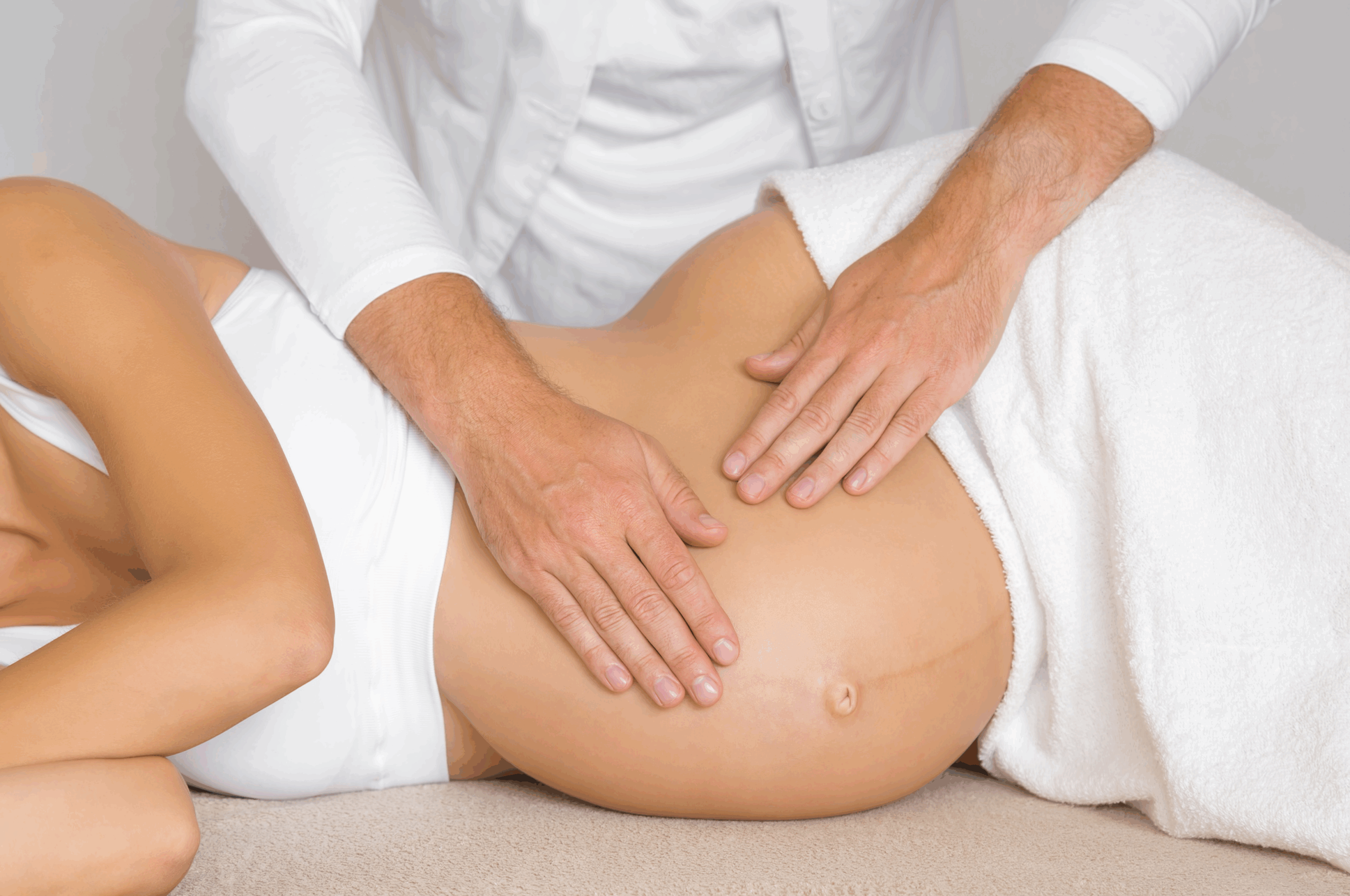 Pregnant woman receiving abdominal massage therapy.